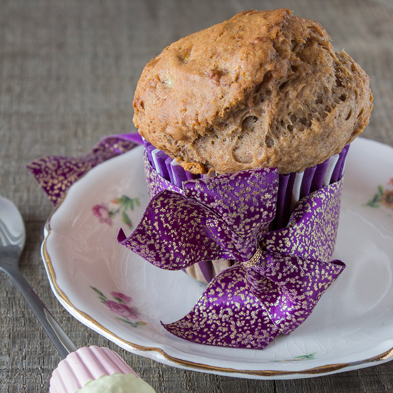 Muffin végane dans une caissette en papier rayé blanc et violet posé sur une assiette