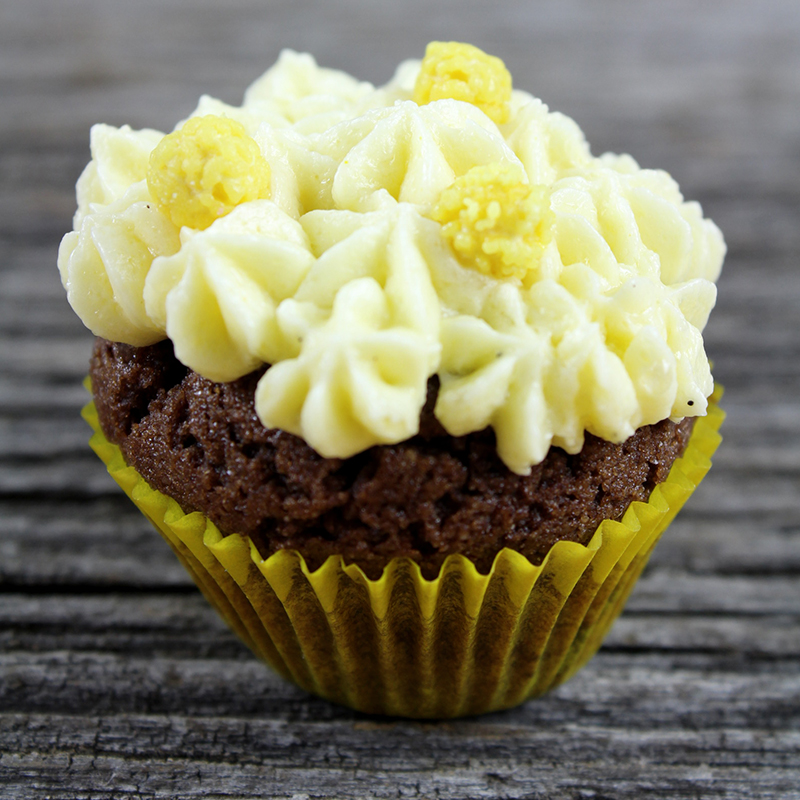 Cupcake chocolat vanille dans caissette jaune sur fond de bois gris